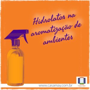 A imagem, toda em todos de roxo e laranja, mostra a foto de um borrifador de ambientes e a frase: Hidrolatos na aromatização de ambientes. Completam a imagem o desenho de uma janela aberta com floreira, que é o logo da Casa Máy, fundada em 2009, e o site www.casamay.com.br.